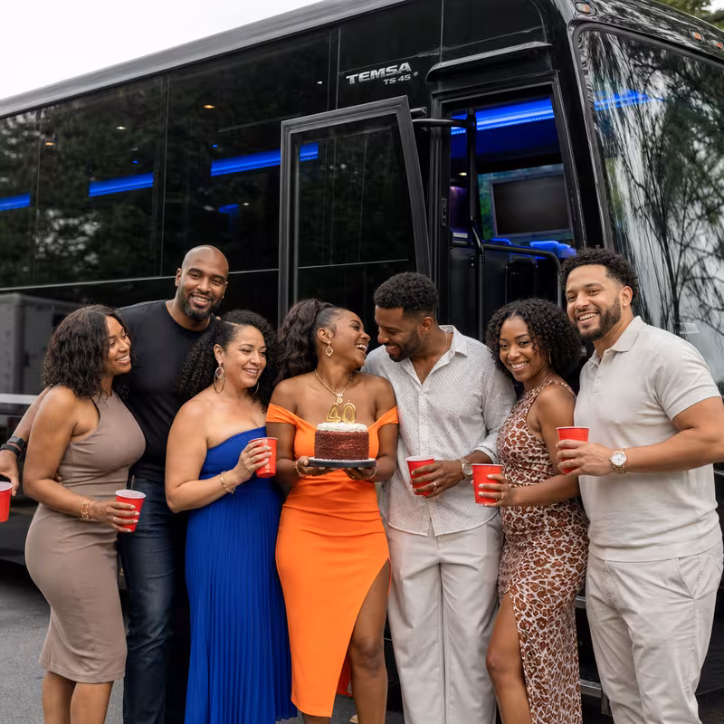 Group boarding a white charter bus for Birthday Transportation transportation in San Bernadino