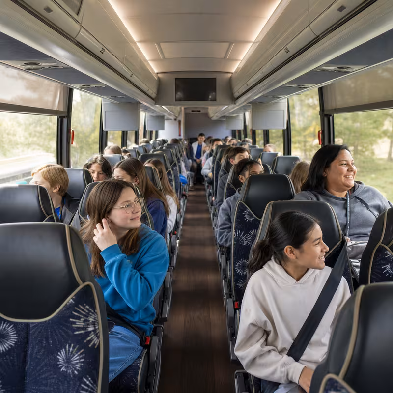 Group boarding a white charter bus for School Transportation transportation in San Bernadino